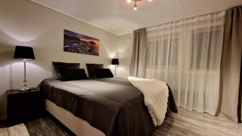 a bedroom with a large bed and a window at Rancho Apartment in Langevåg in Sula
