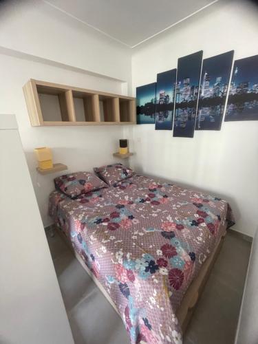 - une chambre avec un lit et des photos sur le mur dans l'établissement appartement les étoiles, à Antibes