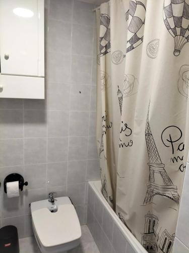 a bathroom with a toilet and a shower curtain at Spacious House in Almuñécar with Terrace 100 m² in Almuñécar