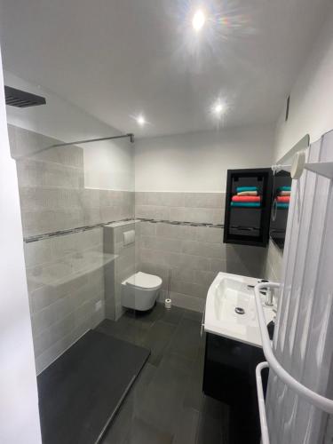 une salle de bain avec des toilettes blanches et un lavabo dans l'établissement appartement les étoiles, à Antibes