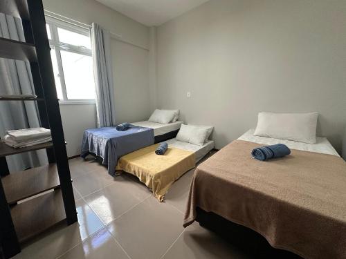 una habitación con dos camas y una ventana en Ap a alguns passos da praia do Bosque | ROGR104, en Rio das Ostras