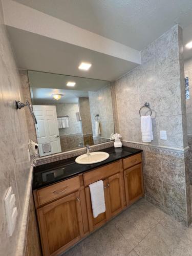 un bagno con un lavandino e un grande specchio di The Queen of Cozumel - Urban Empire En-suite City View - for Couples in Mind a Cozumel