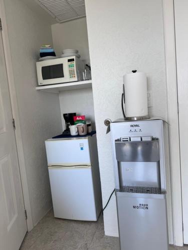 una piccola cucina con piano cottura e forno a microonde di The Queen of Cozumel - Urban Empire En-suite City View - for Couples in Mind a Cozumel