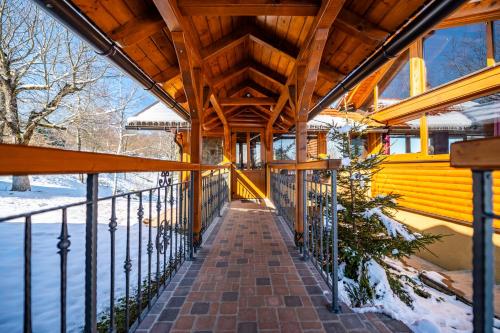 a wooden house with a wooden roof and a walkway at Brezova Poljana Lodge in Vrbovsko