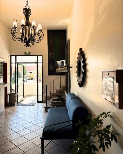 a living room with a couch and a chandelier at Hotel Arboledas Industrial in Guadalajara