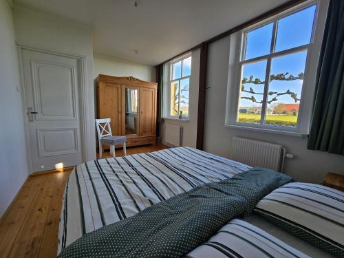a bedroom with a bed and a large window at Appartement Het Voorhuis in Horssen