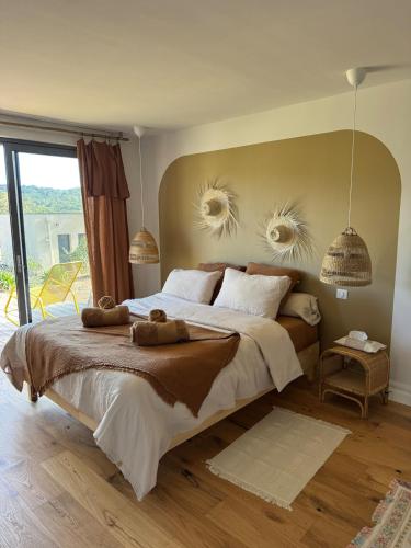 une chambre avec un grand lit avec deux animaux en peluche dessus dans l'établissement Casa Dolce Follia Corsica, near beach , vue sur le Maquis , Corse du sud, à Lecci