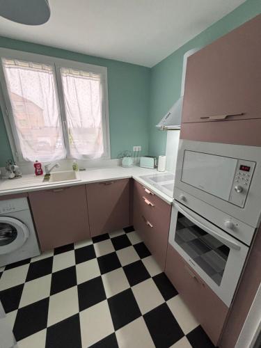 - une cuisine avec un sol en damier noir et blanc dans l'établissement 5 min Moulins Duplex -Clim -wifi -borne d arcade -garage 25 min LE PAL, à Yzeure