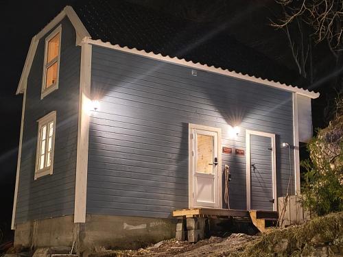 a small blue house with a front door at night at The Perfect Stop - Pinewood Loft in Lødingen