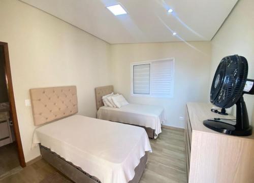 a room with two beds and a fan at Casa de campo em Mairinque in Mairinque