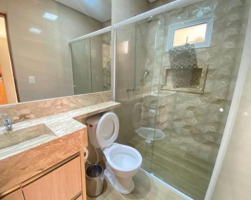 a bathroom with a toilet and a glass shower at Casa de campo em Mairinque in Mairinque