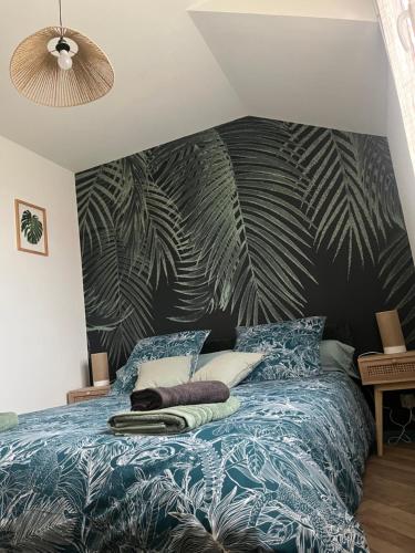 - une chambre avec un lit bleu et un mur verdoyant dans l'établissement 5 min Moulins Duplex -Clim -wifi -borne d arcade -garage 25 min LE PAL, à Yzeure