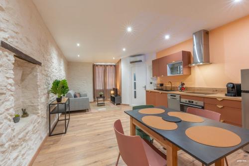 une cuisine et un salon avec une table et des chaises dans l'établissement La tavernne de Balaach Clim Wifi Cozy, à Carcassonne