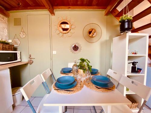 une salle à manger avec une table et des chaises blanches dans l'établissement Cosi studio duplex Teinturiers - WIFI - CLIM -, à Avignon
