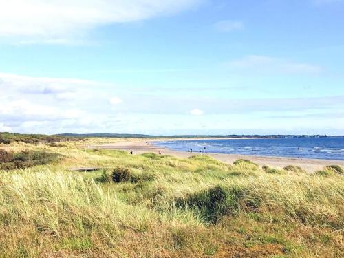a beach with people on the sand and the water at Nice apartment near the beach-By Traum in Mellbystrand