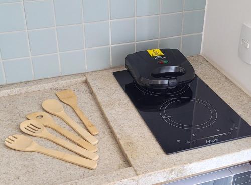 a kitchen counter with a toaster and wooden spatulas at Blend Coliving One - 1 in Ribeirão Preto