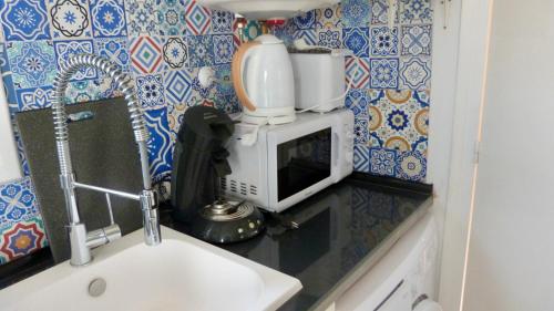 a kitchen with a coffee maker on top of a microwave at Casa Límon in Torredembarra