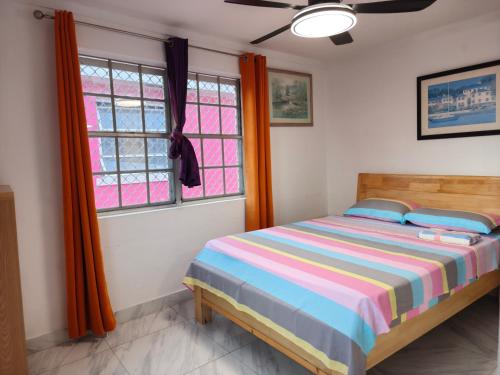 a bedroom with a bed and two windows at Da Pink And White Palace in Nassau