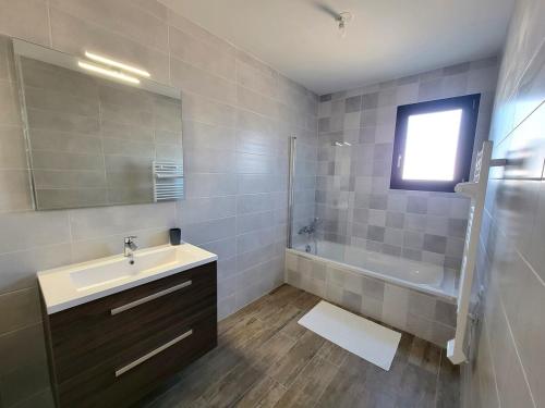 une salle de bain avec un lavabo, une baignoire et un miroir dans l'établissement Cottage de Villepey, villa near beach, swimming pool, à Fréjus