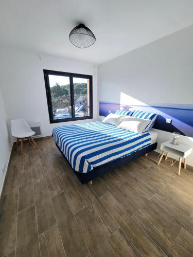 une chambre avec un lit à rayures bleues et blanches dans l'établissement Cottage de Villepey, villa near beach, swimming pool, à Fréjus