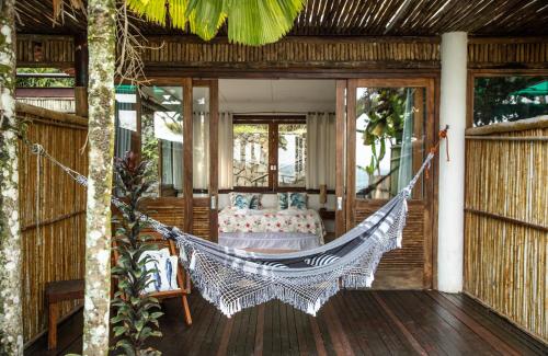 a hammock on the porch of a house at Paraíso Azul Retiro in Abraão