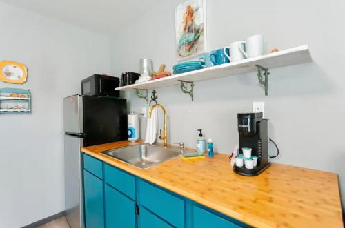 a kitchen counter with a sink and a refrigerator at Breakwater Resort in Grayland