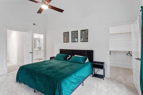 a bedroom with a green bed and a ceiling fan at Home Near Lenovo Center and Carter Finley in Raleigh