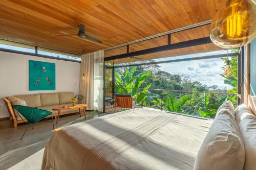 a bedroom with a bed and a large window at The Green House, Santa Teresa - Adults Only in Santa Teresa Beach