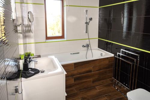 a bathroom with a tub and a sink and a shower at Alsóerdő Villa Resort in Zalaegerszeg