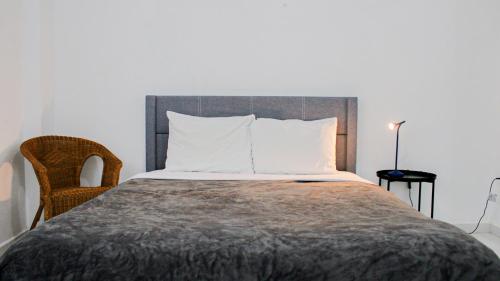 a bedroom with a large bed and a chair at Arecibo Hotel 2104 in Arecibo