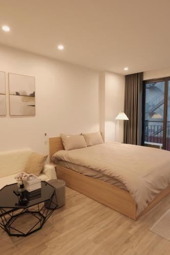 a bedroom with a large bed and a table at Sam Sam Studio - 2 Dragons WestLake - Washing machine in Hanoi