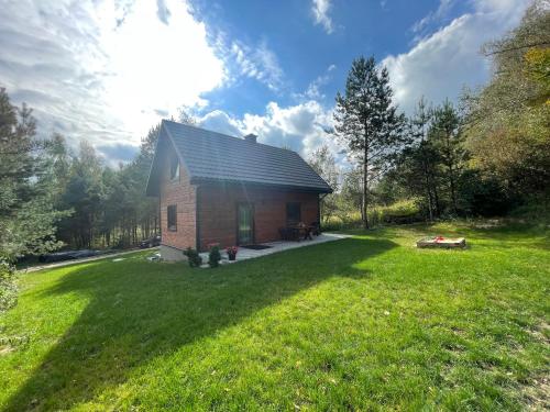 a small house in the middle of a yard at Domek na Zagórze - domek całoroczny in Krasnobród