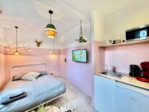 une petite chambre avec un lit et un lavabo dans l'établissement Amety, à Colmar