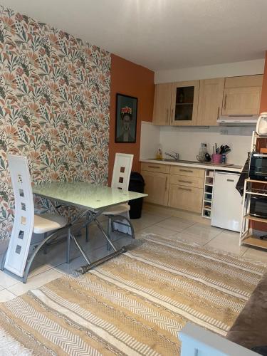 une cuisine avec une table et des chaises dans une pièce dans l'établissement Le Val Fleuri, à Sète