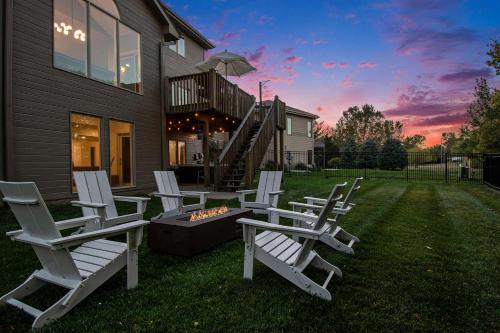 a group of chairs sitting in the grass in front of a house at Stunning 5BR Villa Large Hot Tub & Scenic Yard in Bennington