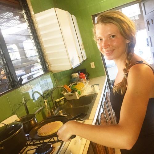 a woman standing in a kitchen cooking food at Casa Areka in Panama City