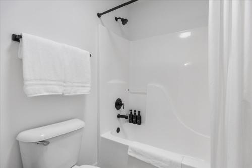 a white bathroom with a toilet and a shower at 6BR Luxury Stay Prime Spot Games & More in Millard