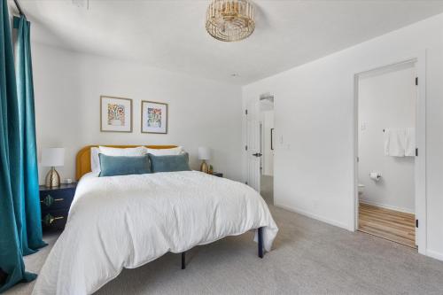 a white bedroom with a large bed with blue pillows at 6BR Luxury Stay Prime Spot Games & More in Millard