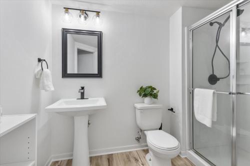 a white bathroom with a toilet and a sink at 6BR Luxury Stay Prime Spot Games & More in Millard