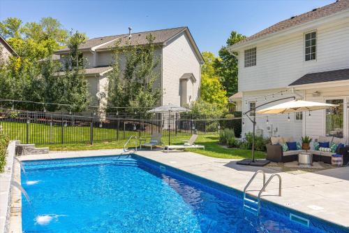 a swimming pool in a yard next to a house at 6BR Luxury Stay Prime Spot Games & More in Millard