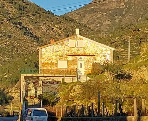 une voiture garée devant une maison avec une montagne dans l'établissement Piscinas, Serra da Estrela AL, à Bouça