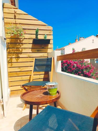 un patio avec une table et des chaises sur un balcon dans l'établissement LE LOGIS, Appartement au pied de la plage, à Port-la-Nouvelle