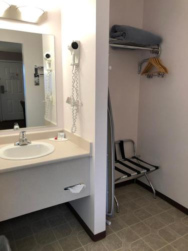 a bathroom with a sink and a mirror at Super 8 by Wyndham Lake Country/Winfield Area in Winfield