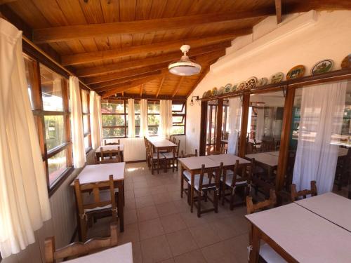 a dining room with tables and chairs and windows at Hotel Dubrava in Ostende