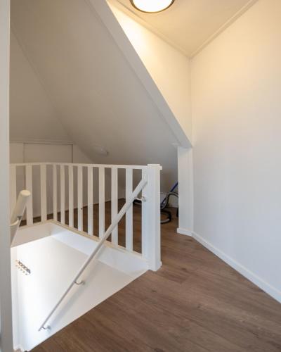 a white staircase in a room with a ceiling at Brugs home 2 in Barneveld