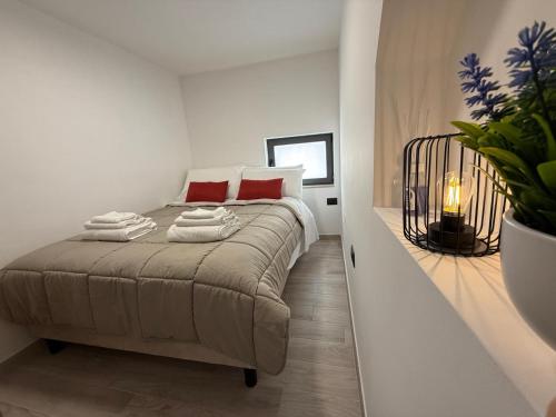 a white bedroom with a bed with red pillows at A Volte nel Salento-Porta Napoli in Lecce