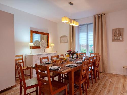 a dining room with a wooden table and chairs at Gite Etoile du berger in Ouarville