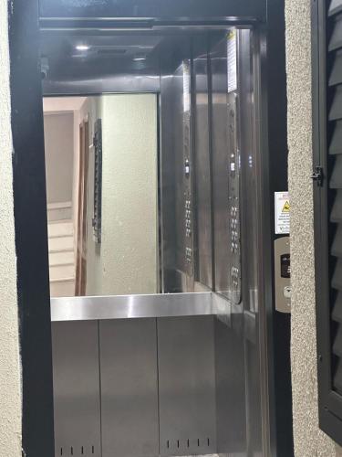 Puerta de cristal con espejo en una habitación en apartamento recreio 5 min da praia, en Río de Janeiro