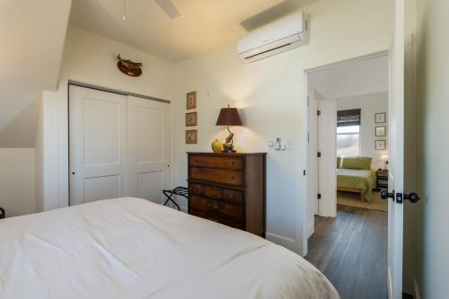 a bedroom with a white bed and a dresser with a lamp at Brand New Waterfront Construction in Bluff City