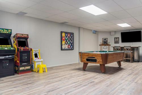 a room with a ping pong table and arcade games at Majestic VIEWS FunAmenities & Best for Huge Group in Council Bluffs